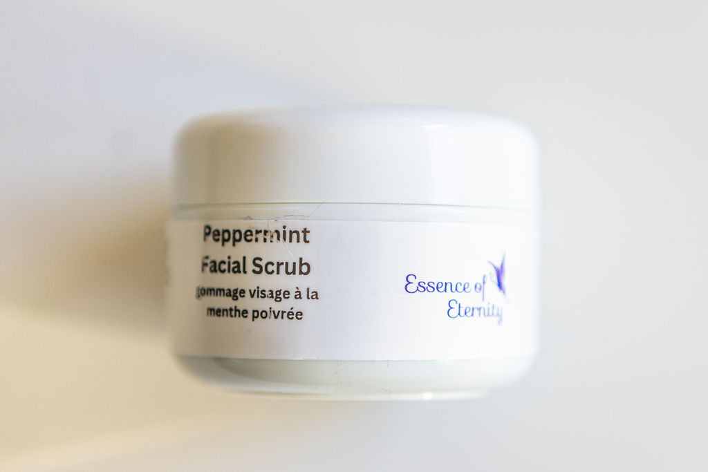 Essence of Eternity peppermint facial scrub in 30g jar, showing textured green scrub with peppermint leaves for skincare.
